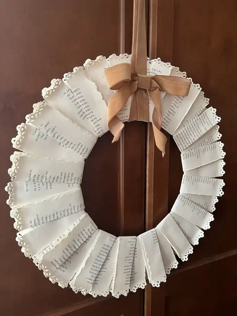 Finished DIY book page wreath made with folded vintage book pages and velvet ribbon